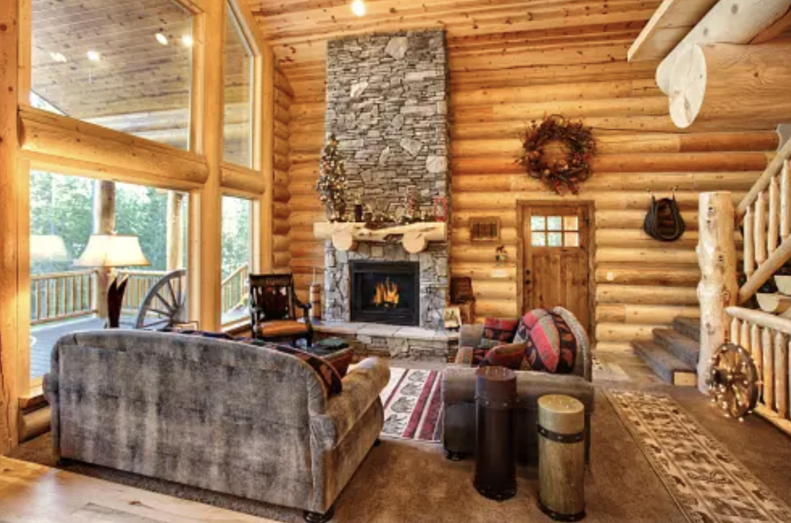 ビーム＆ポスト風の、大きな窓ガラスが特徴の家の今に石造りの暖炉がある。